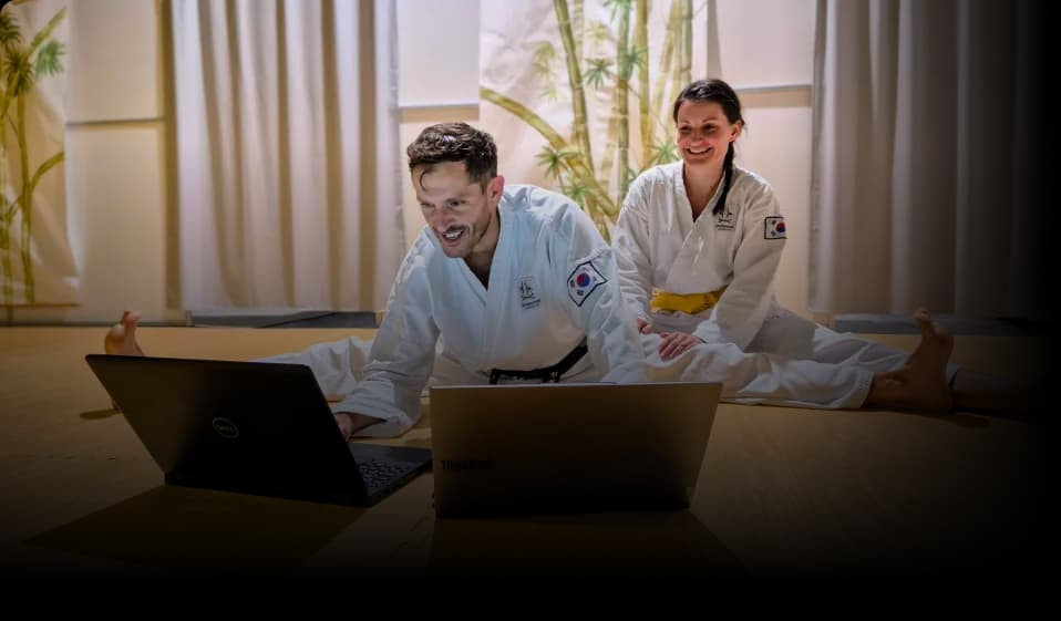 Das Sportanize-Gründerteam in Taekwondo-Doboks arbeitet gemeinsam am Laptop an der Vereinssoftware für Kampfsportschulen